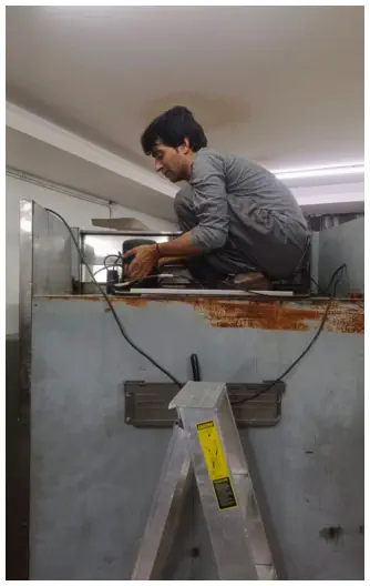 Technician repairing an under-counter commercial chiller
